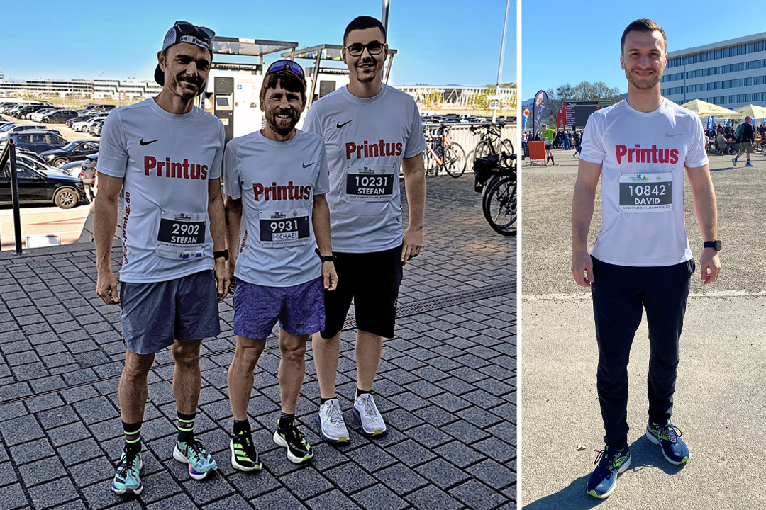 Vier Mitarbeitende von Printus in Sportkleidung mit Startnummern beim Freiburg Marathon – gemeinsames Teamevent bei Sonnenschein