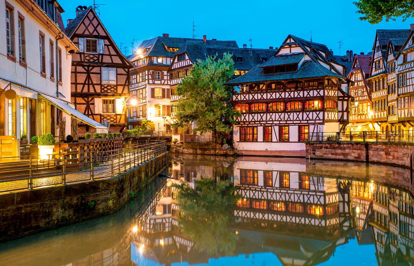 Abendliche Ansicht von Fachwerkhäusern am Wasser in einem historischen Stadtteil, mit Spiegelung im Kanal