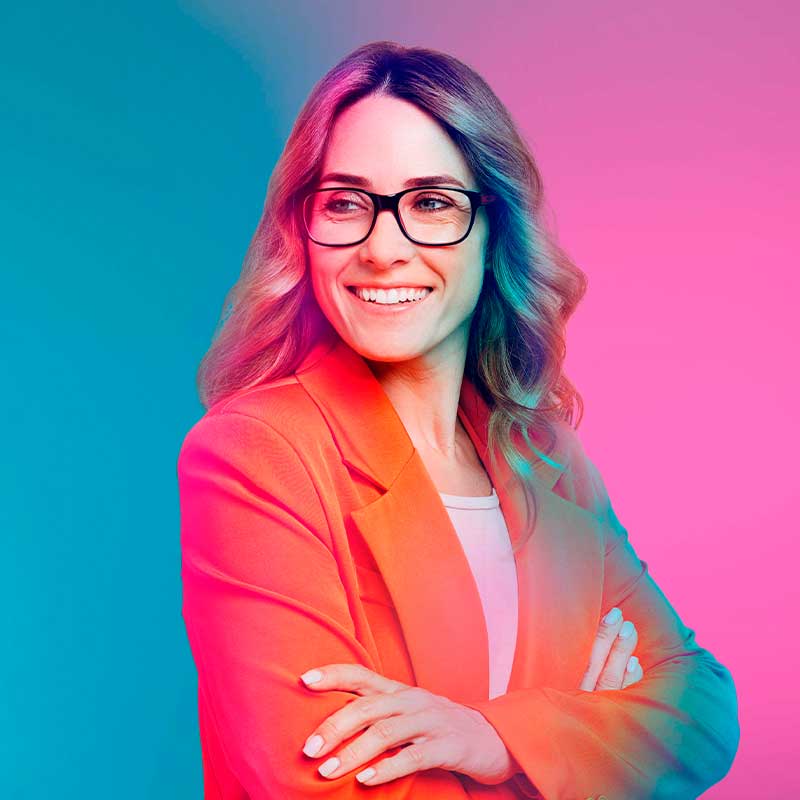 Selbstbewusste Frau mit Brille und rotem Blazer, blickt lächelnd zur Seite – Symbolbild für berufserfahrene Fachkräfte bei Printus