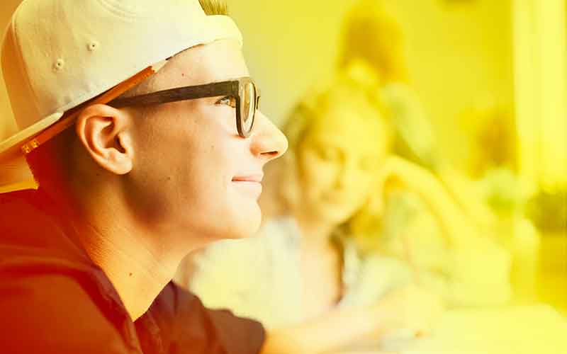 Junger Schüler mit Brille und Cap blickt nachdenklich nach vorne – Motivation und Zukunftsperspektive bei Printus