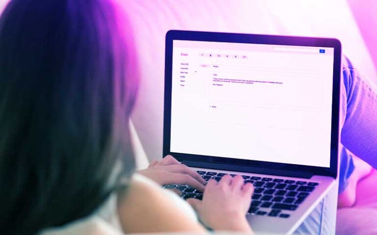 Junge Frau verfasst eine E-Mail auf dem Laptop – symbolisches Bild für die erste Kontaktaufnahme bei einer Bewerbung