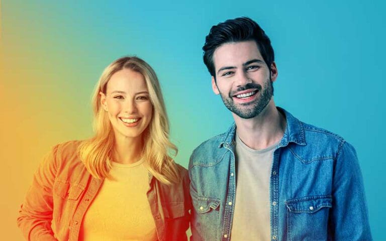 Junge Frau und junger Mann lächeln in die Kamera – Symbolbild für motivierte Berufseinsteiger mit frischem Know-how